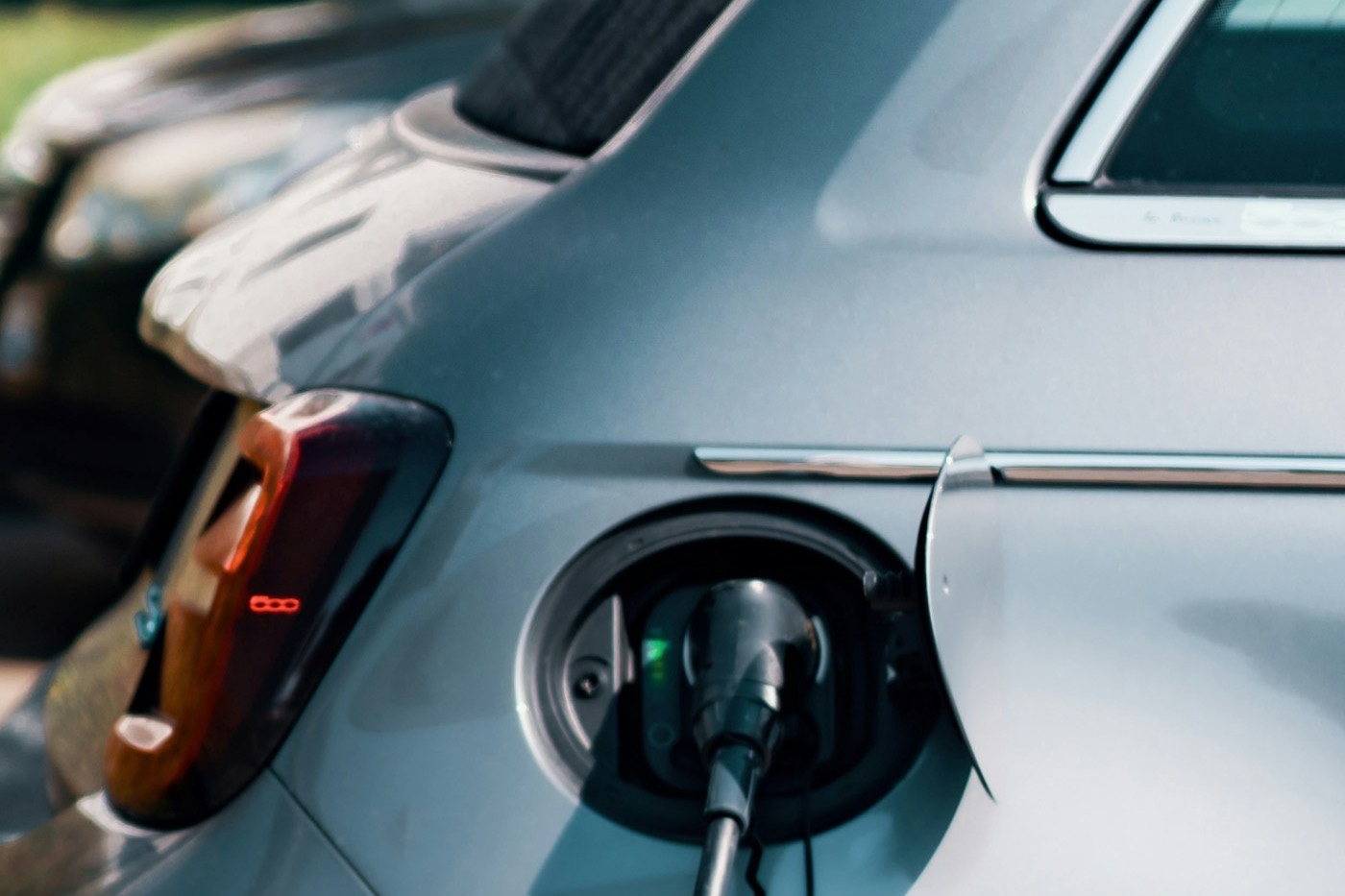 Geöffnete Ladeklappe eines Fiat 500e mit eingestecktem Typ-2-Ladestecker